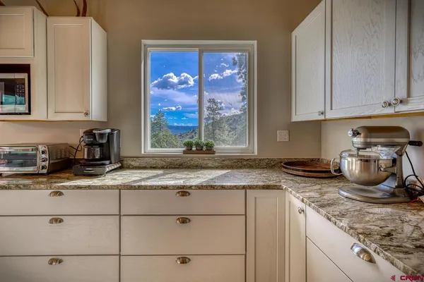 a kitchen with granite countertop kitchen island a stove a sink and cabinets