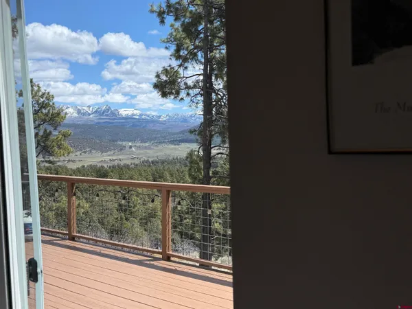 a view of a balcony with wooden floor and outdoor seating