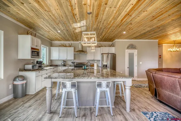 a large kitchen with stainless steel appliances granite countertop a stove and cabinets