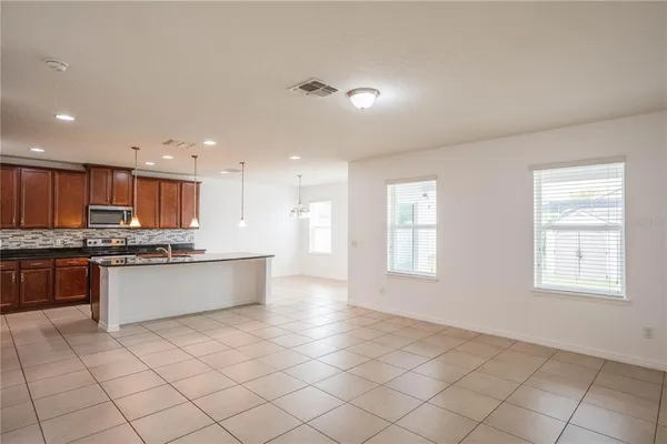 a large kitchen with kitchen island granite countertop a window and white cabinets