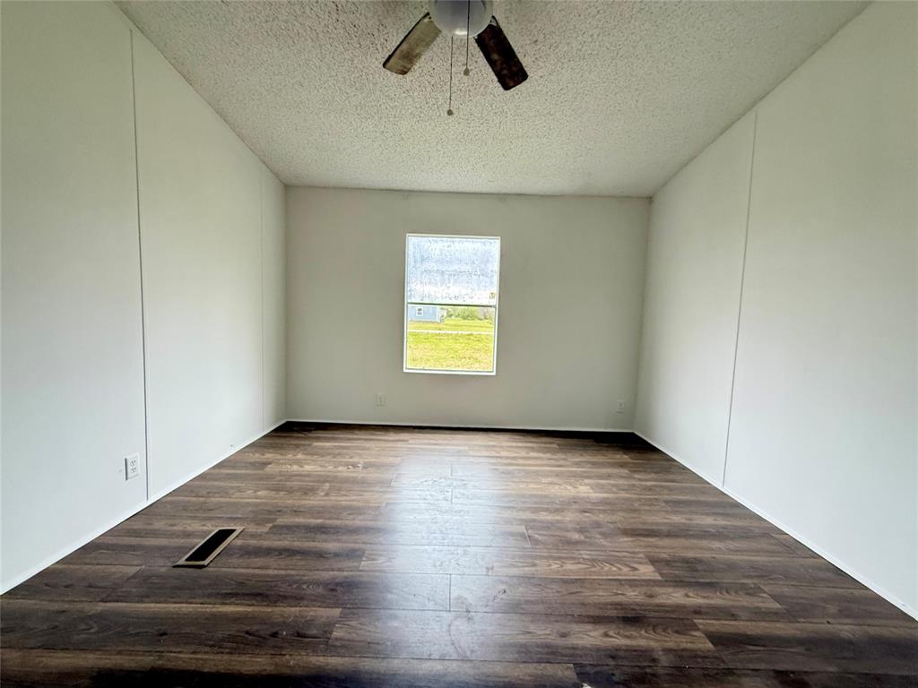 9123 Rodeo Drive Terrell, TX 75160 - Photo 7 of 16 wooden floor in an empty room with a window