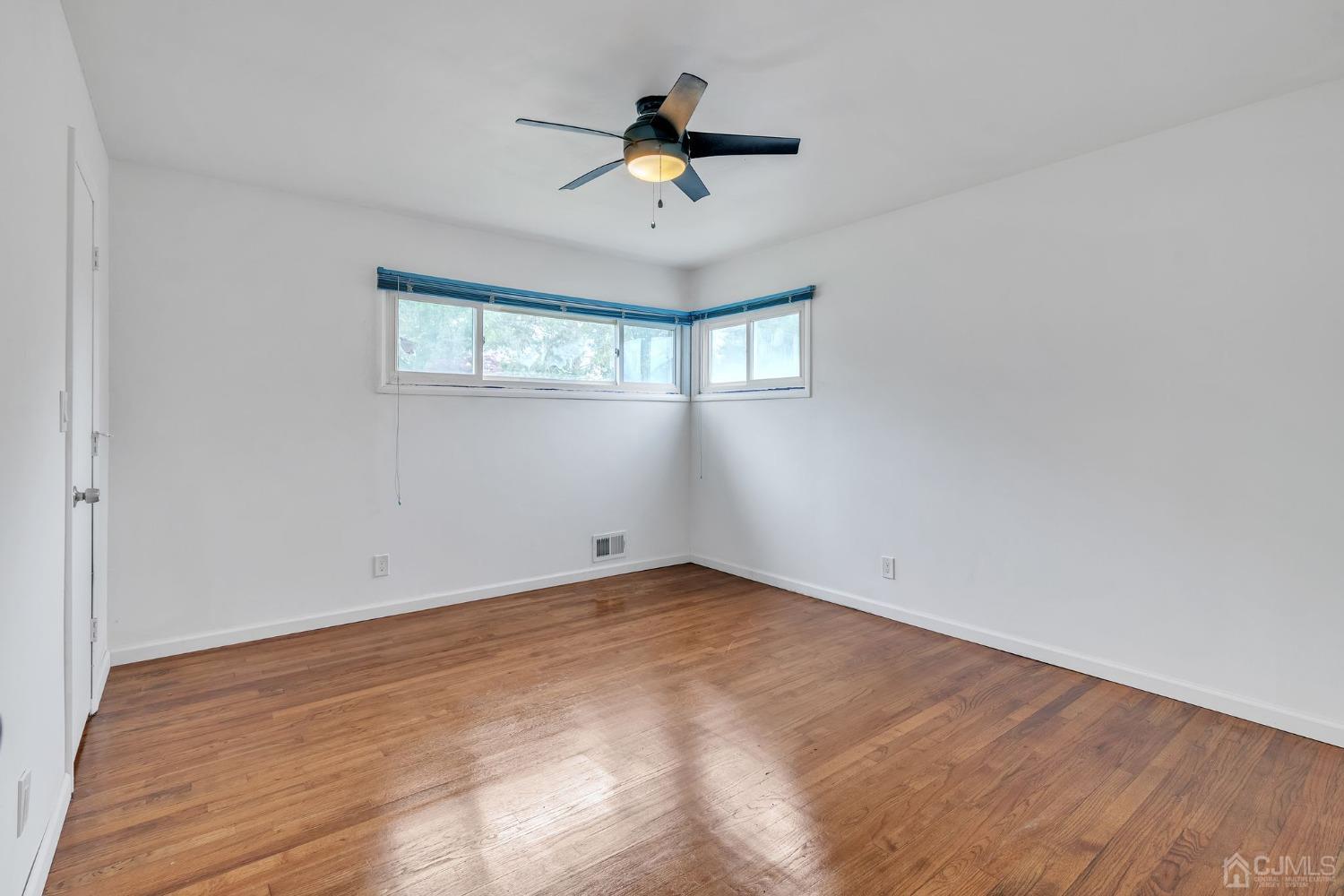 129 Princeton Road Old Bridge, NJ 08859 - Photo 13 of 26 wooden floor in an empty room with a window