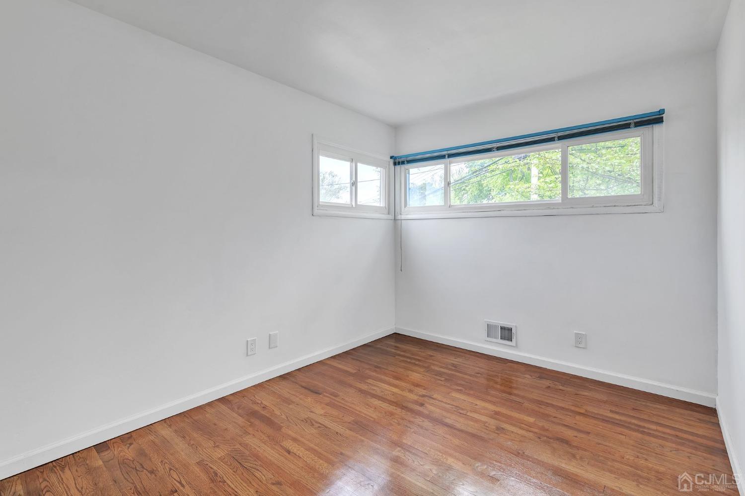 129 Princeton Road Old Bridge, NJ 08859 - Photo 15 of 26 an empty room with wooden floor and windows