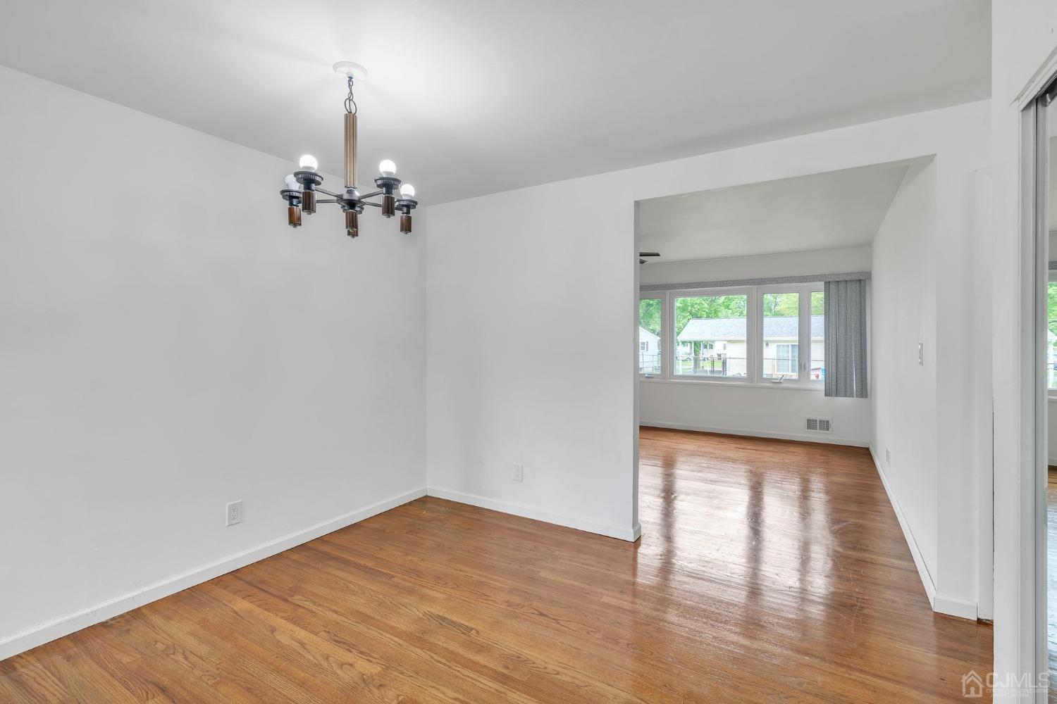 129 Princeton Road Old Bridge, NJ 08859 - Photo 4 of 26 wooden floor in an empty room with a window