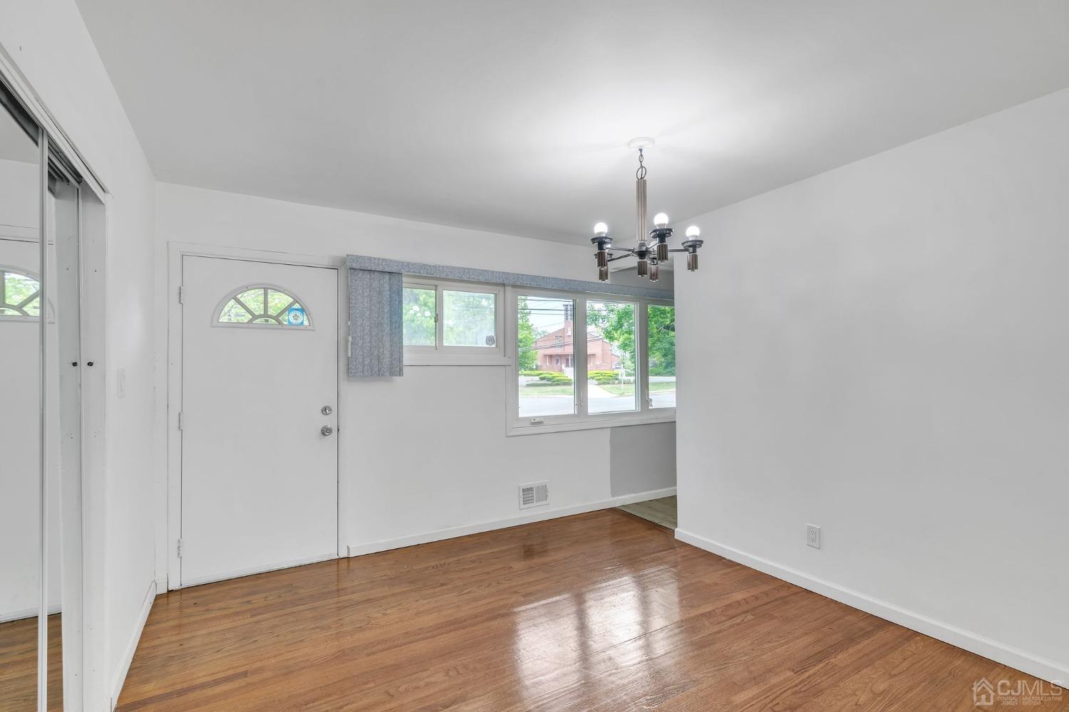 129 Princeton Road Old Bridge, NJ 08859 - Photo 5 of 26 a view of an empty room with window and wooden floor