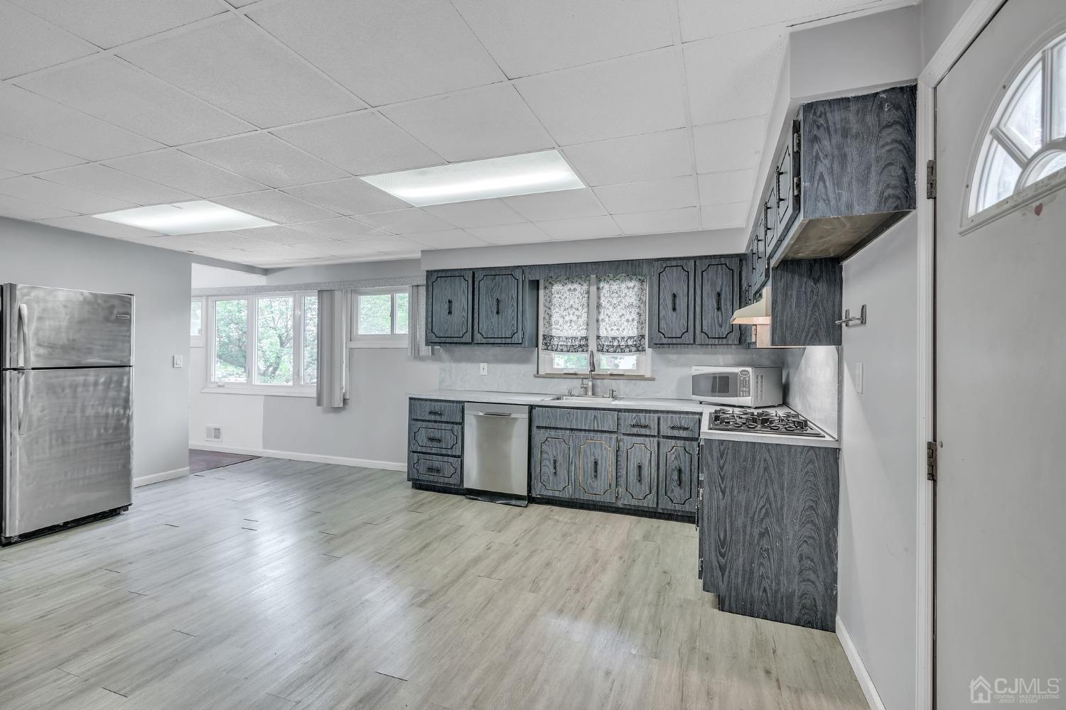 129 Princeton Road Old Bridge, NJ 08859 - Photo 9 of 26 a kitchen with stainless steel appliances granite countertop a refrigerator a sink dishwasher a stove top oven a refrigerator and white cabinets with wooden floor