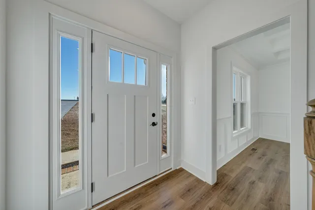 a view of a hallway with wooden floor and staircase