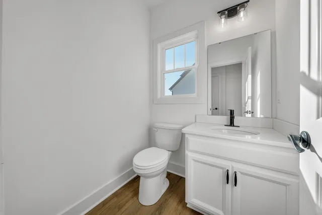 an empty room with wooden floor and ceiling fan