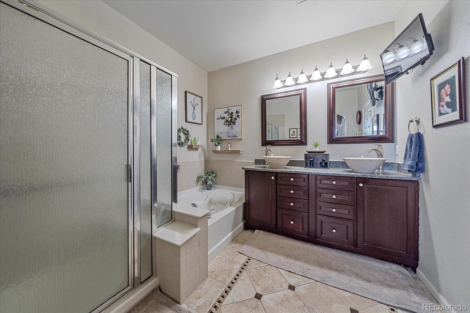 13721 Plaster Point, Unit 102 Broomfield, CO 80023 - Photo 13 of 35 a spacious bathroom with a granite countertop sink mirror and shower
