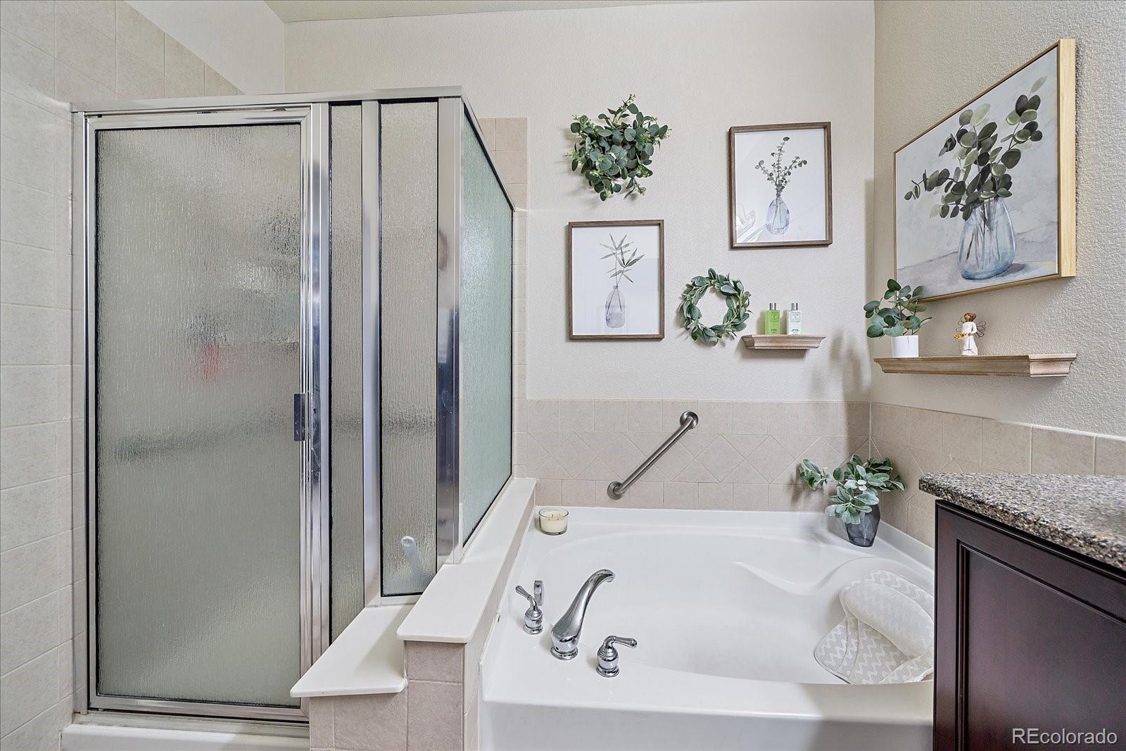 13721 Plaster Point, Unit 102 Broomfield, CO 80023 - Photo 14 of 35 a bath tub sitting next to a white sink and vanity