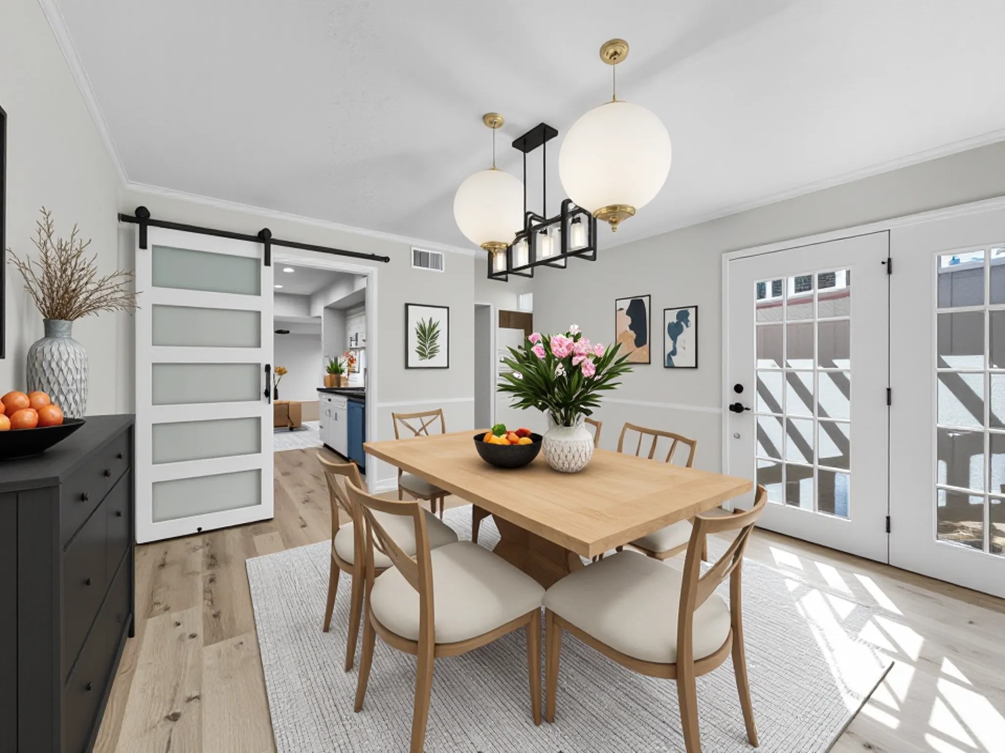 2243 West Alabama Street, Unit 10 Houston, TX 77098 - Photo 13 of 45 Virtually staged dining room features a modern design with a wooden table and chairs on a light rug. It has ample natural light from the French doors, a stylish chandelier, and a sliding barn door leading to the kitchen. Decor includes wall art and a mix of plants and fruit bowls, creating a cozy, welcoming atmosphere.
