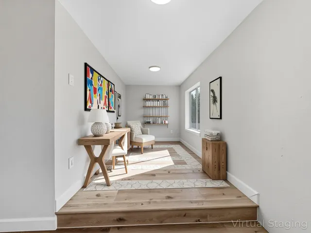 a view of a livingroom with wooden floor and furniture