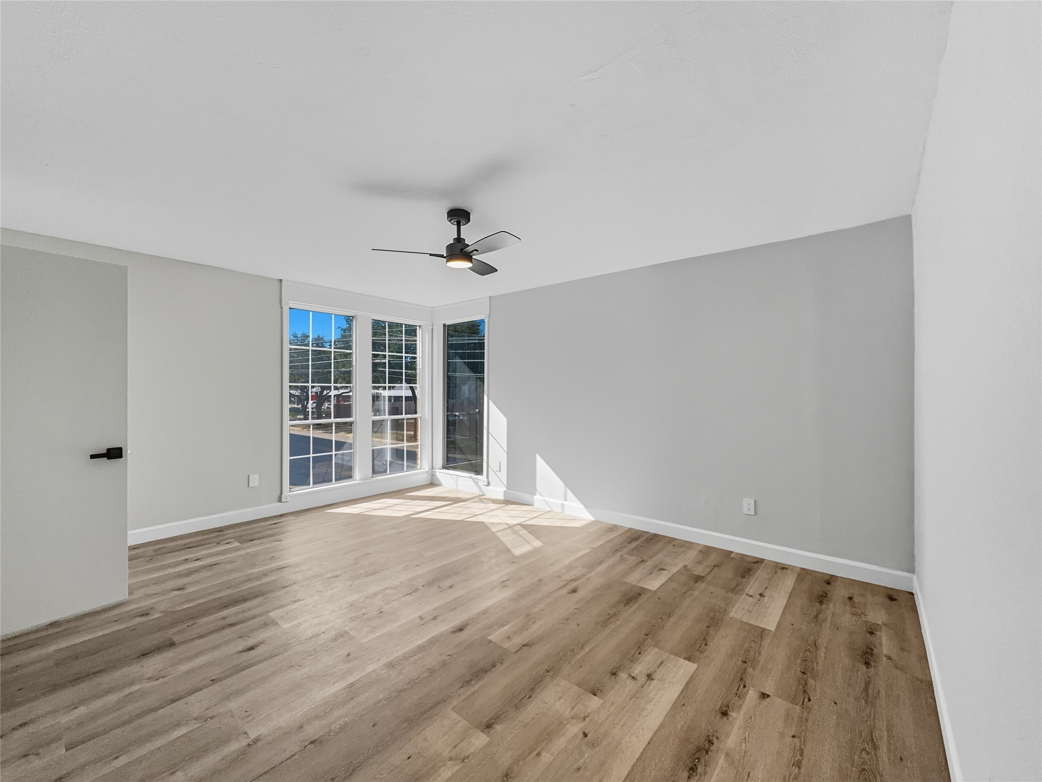 2243 West Alabama Street, Unit 10 Houston, TX 77098 - Photo 29 of 45 This bright and airy room features large windows for plenty of natural light, light wood flooring, and a modern ceiling fan, creating a welcoming and spacious atmosphere.