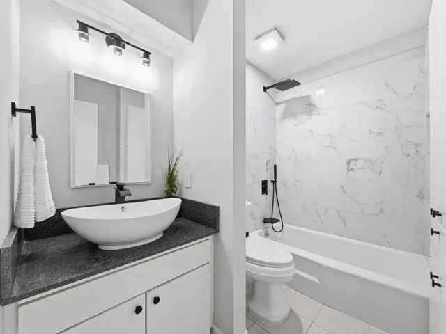 a bathroom with a sink a toilet a mirror and shower