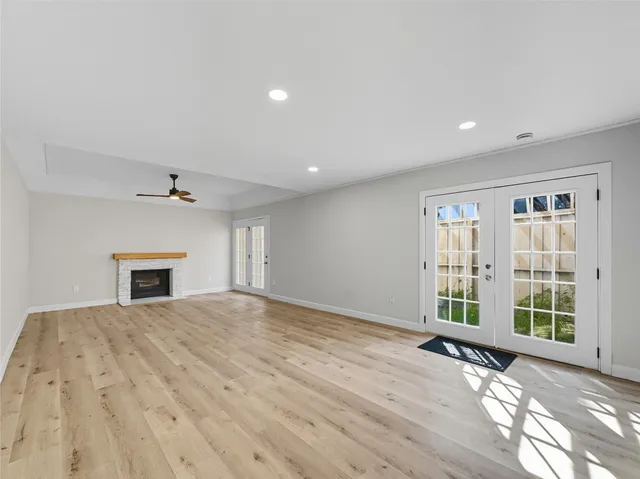 a view of an empty room with a window and fireplace