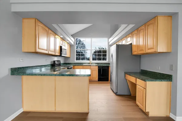 a kitchen with stainless steel appliances granite countertop a stove a sink and a refrigerator