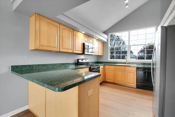 a kitchen with stainless steel appliances granite countertop a sink a stove and a microwave