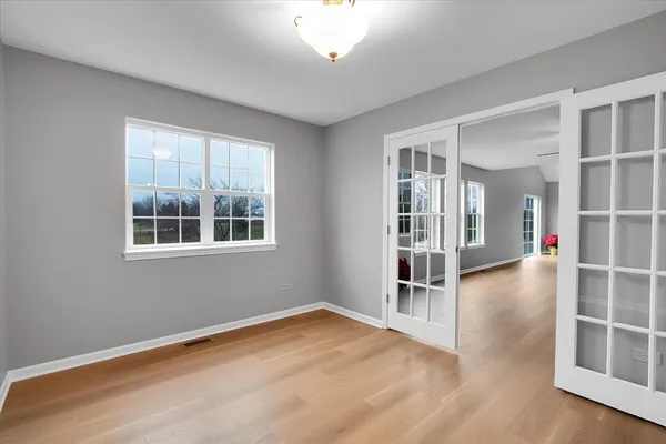 a view of an empty room with a window and wooden floor