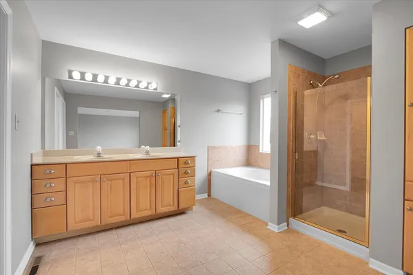 a spacious bathroom with a mirror a shower and a sink