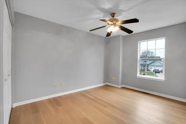 an empty room with window and ceiling fan