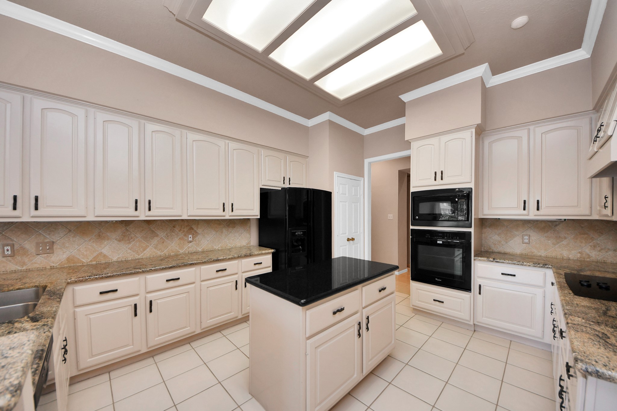 39 Wild Meadow Court The Woodlands, TX 77380 - Photo 15 of 41 a kitchen with granite countertop white cabinets and stainless steel appliances