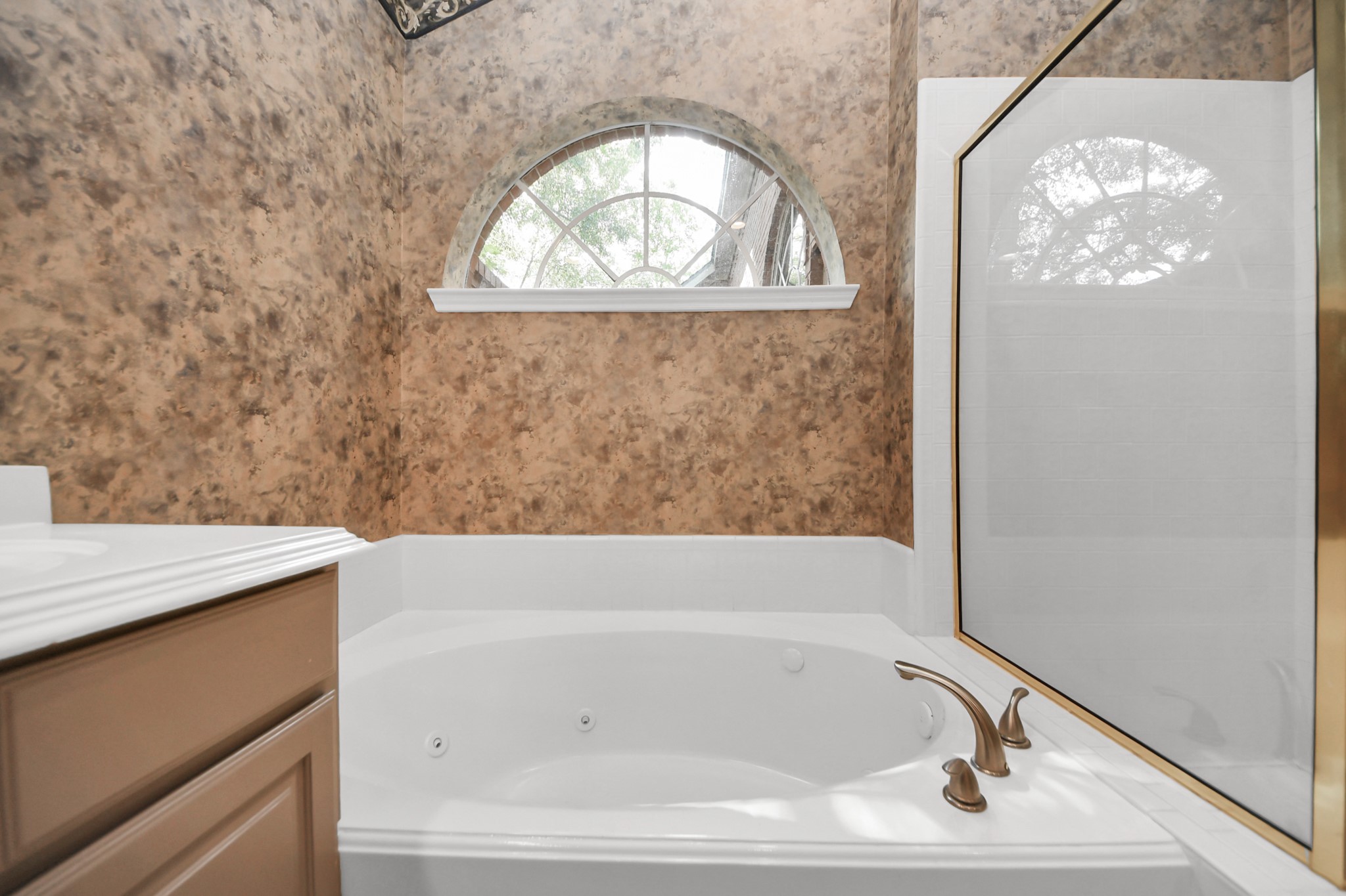 39 Wild Meadow Court The Woodlands, TX 77380 - Photo 22 of 41 a bathroom with a tub and a window
