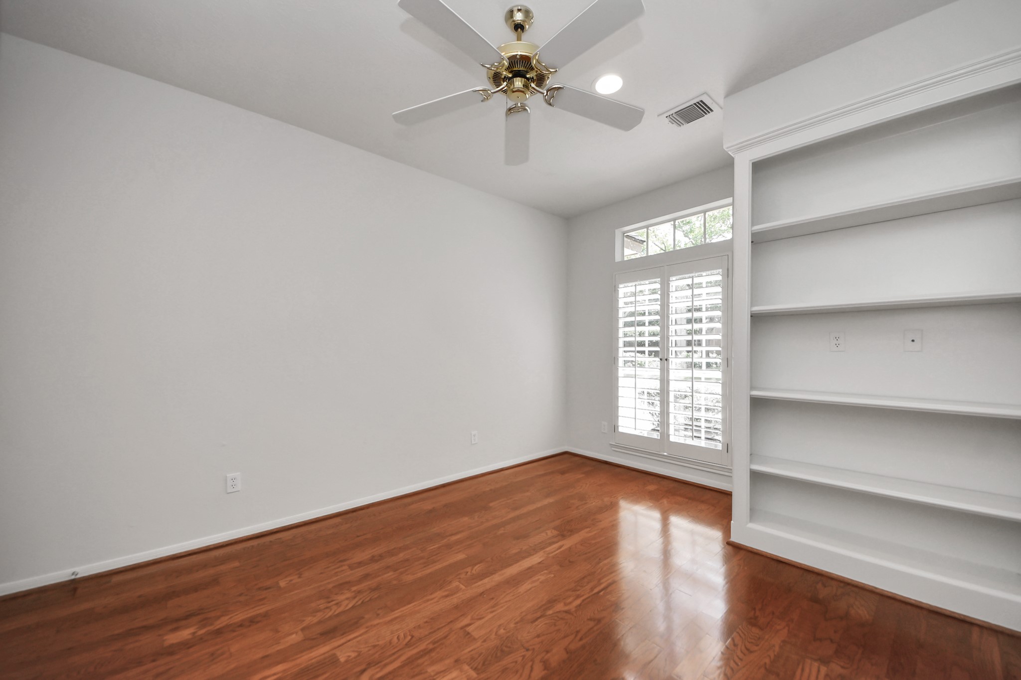 39 Wild Meadow Court The Woodlands, TX 77380 - Photo 28 of 41 a view of an empty room with a window and wooden floor