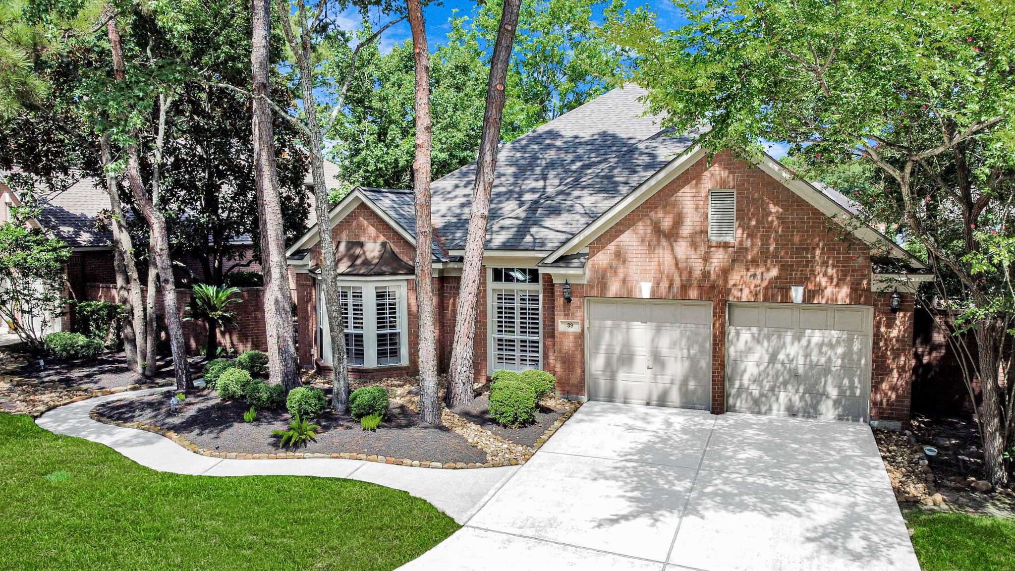 39 Wild Meadow Court The Woodlands, TX 77380 - Photo 5 of 41 a front view of a house with a yard and potted plants
