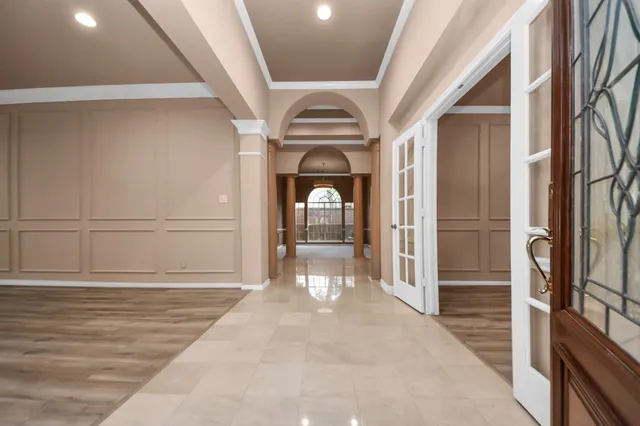 an empty room with wooden floor cabinet and windows