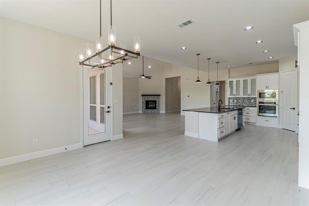 26 Kentucky Court Van Alstyne, TX 75495 - Photo 12 of 40 a view of a kitchen with a refrigerator and a chandelier