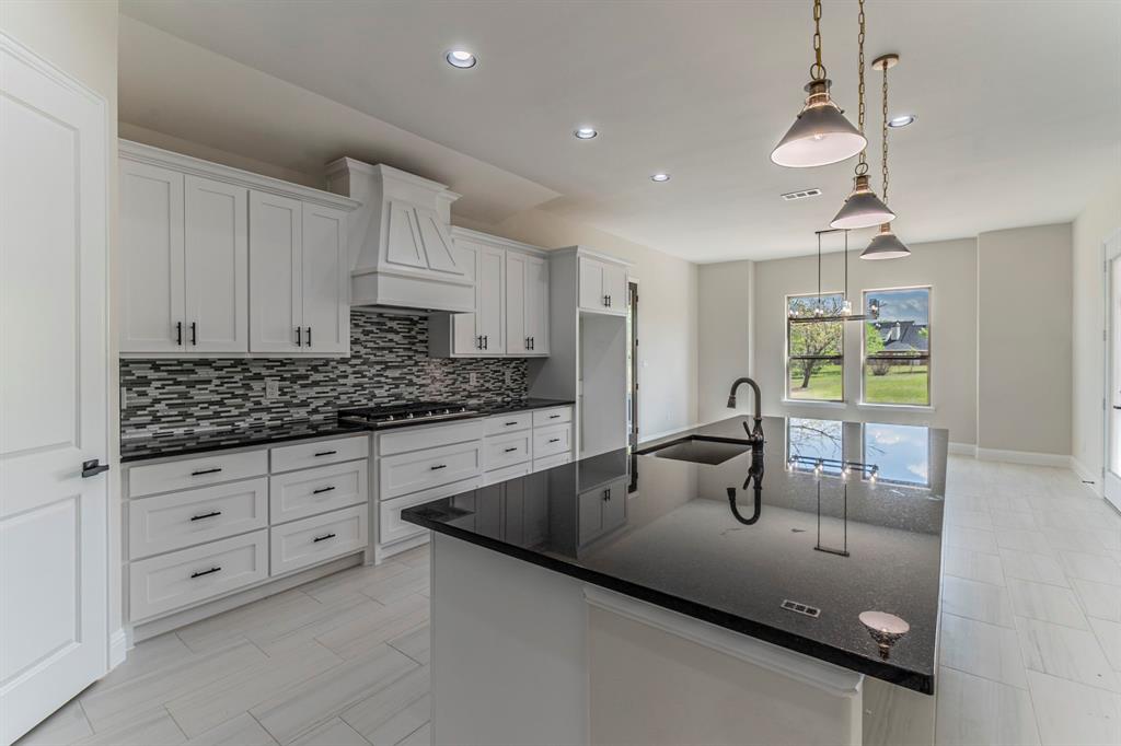 26 Kentucky Court Van Alstyne, TX 75495 - Photo 6 of 40 a kitchen with granite countertop a sink and white cabinets