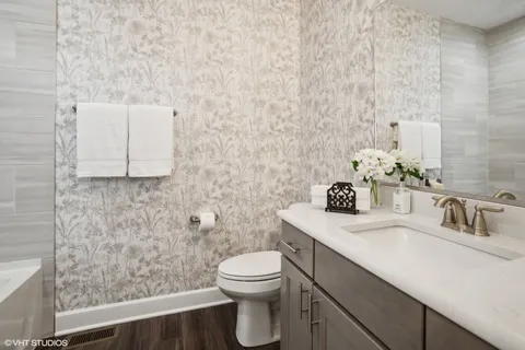 a bathroom with a sink a toilet and mirror