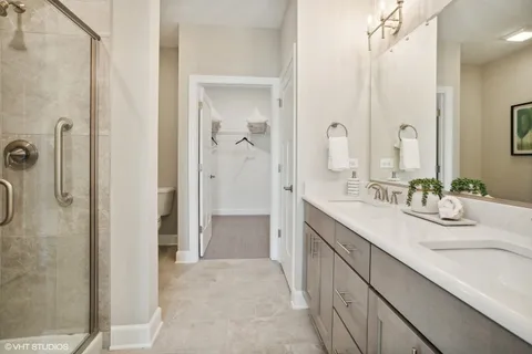 a bathroom with a double vanity sink mirror and shower
