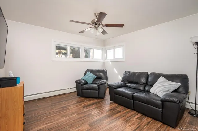 a living room with furniture and a ceiling fan