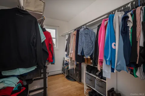 a view of walk in closet with clothes and shoes