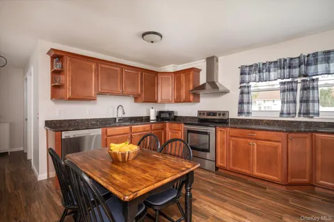 a kitchen with granite countertop wooden cabinets a counter top space and stainless steel appliances