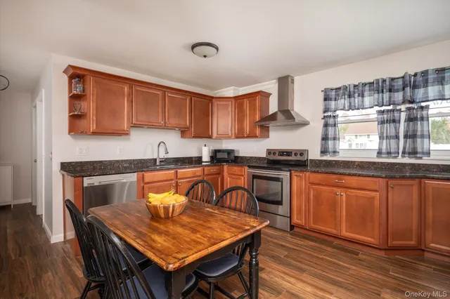 a kitchen with granite countertop wooden cabinets a counter top space and stainless steel appliances