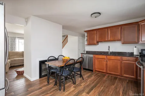 a kitchen with granite countertop wooden floors and wooden cabinets