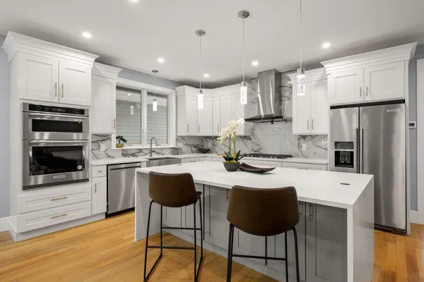 a kitchen with stainless steel appliances granite countertop a sink refrigerator and cabinets