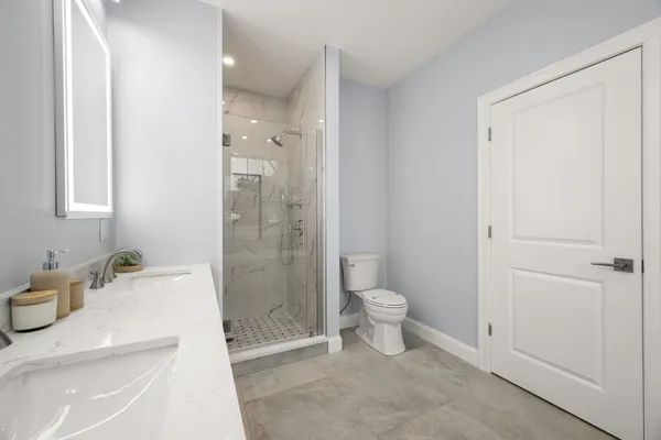 a bathroom with a sink a toilet and shower