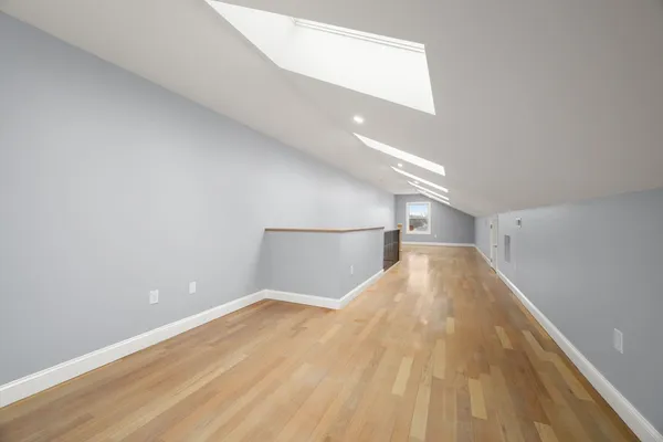 a view of empty room with wooden floor