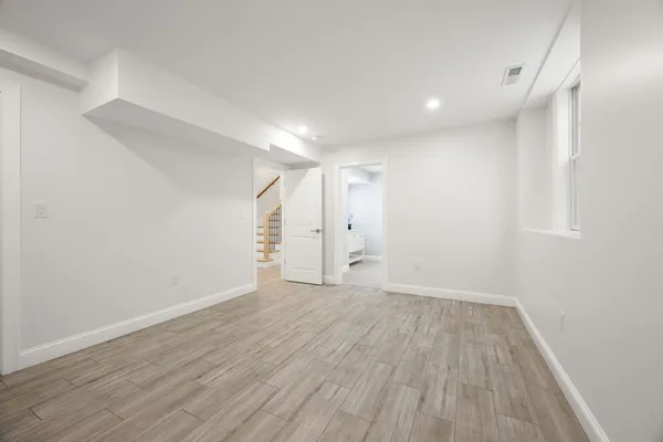 a view of an empty room with wooden floor