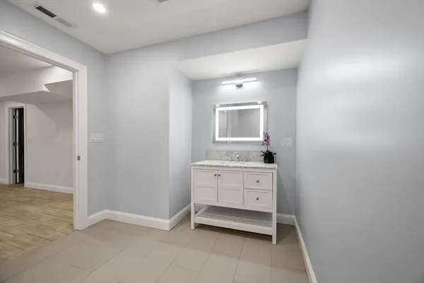 a room with a sink and a mirror