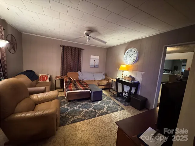 a living room with furniture a clock on wall and a window