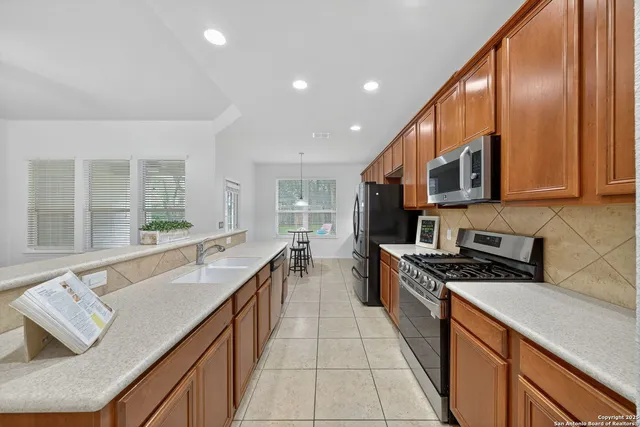 a large kitchen with stainless steel appliances granite countertop a sink and cabinets