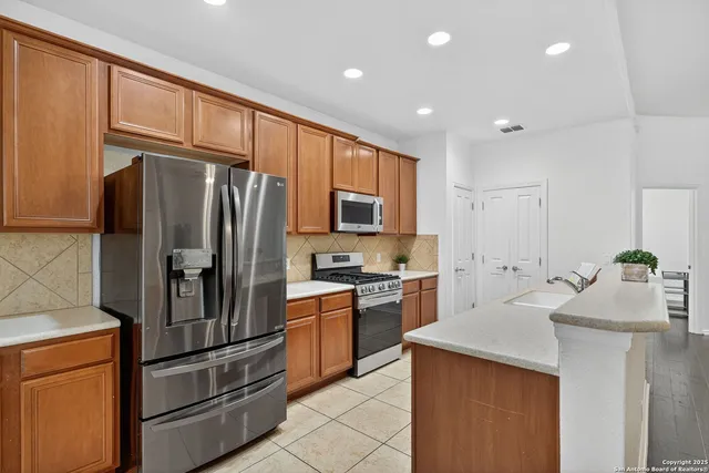 a kitchen with stainless steel appliances granite countertop a refrigerator sink and stove