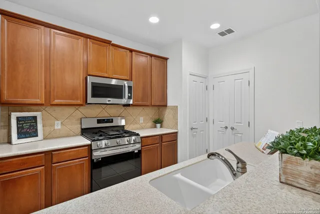 a kitchen with a sink stainless steel appliances and cabinets
