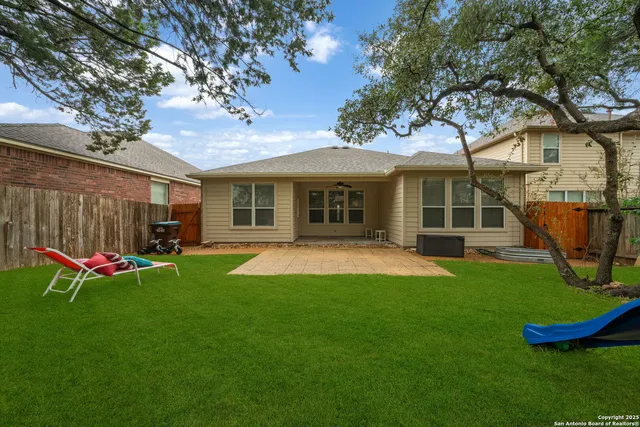 a view of a house with a yard porch and a large tree