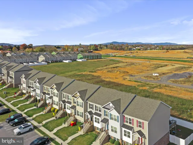 an aerial view of residential building with outdoor space ocean and trees