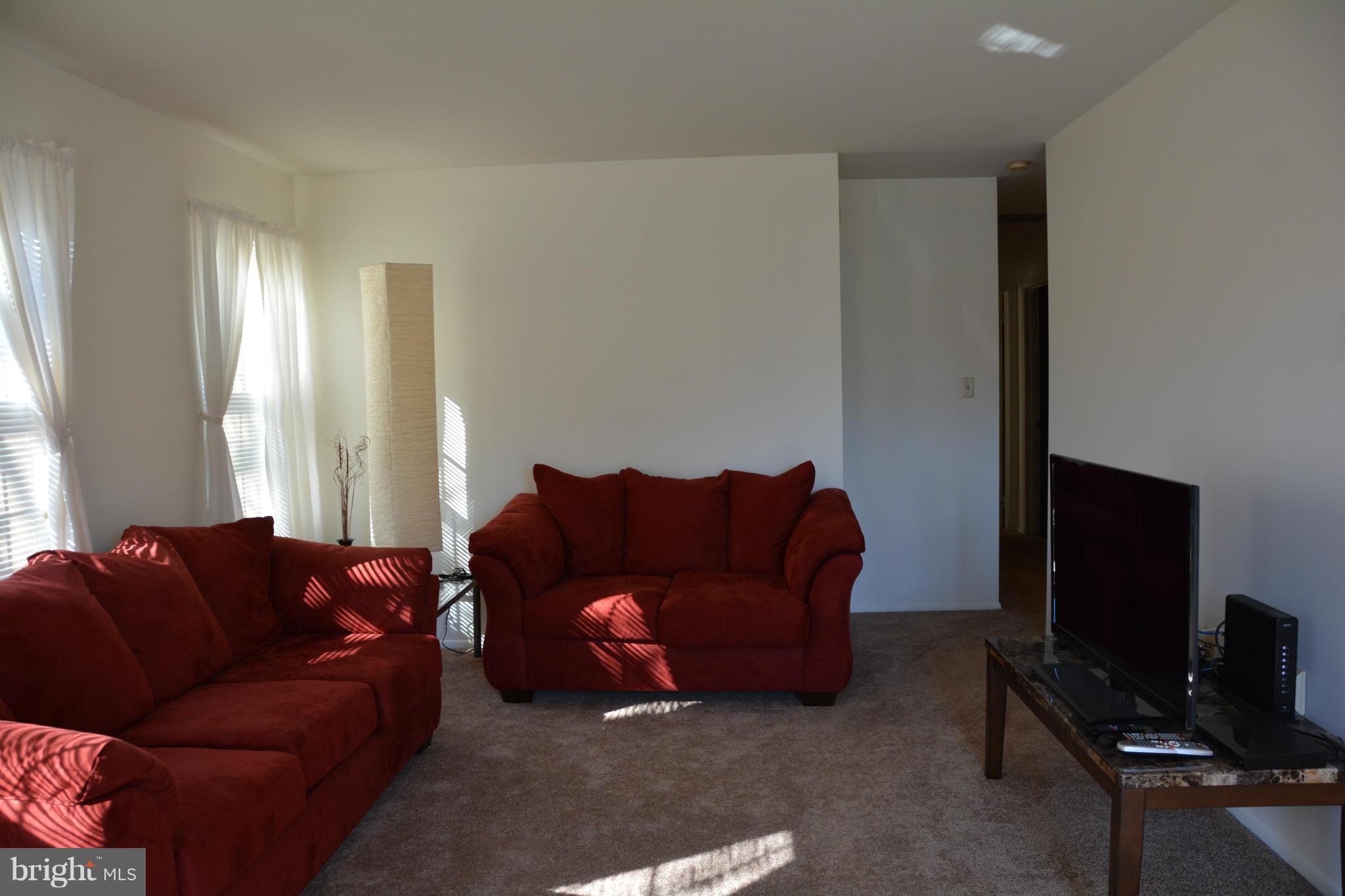 7004 Basswood Road Frederick, MD 21703 - Photo 7 of 16 a living room with furniture a flat screen tv and a window